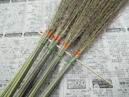 ホウキを作るために、少量のすすきを纏めたものを4束作り、長さを揃えるために串にさしている画像